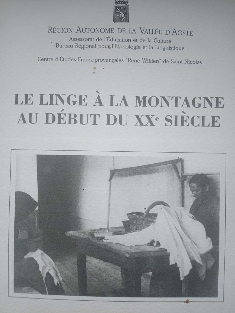 couverture : le linge à la montagne au début du XXe siècle, deux femmes qui cousent deux draps blancs, avec une table en bois sombre sur laquelle il y a un panier en osier